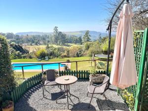a patio with a table and chairs and a umbrella at Gateside Guesthouse in Hilton