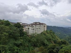 budynek na zboczu wzgórza z drzewami w obiekcie TWIN LAKES TAGAYTAY BELVEDERE condo apartment with Over-looking w mieście Balibaguhan