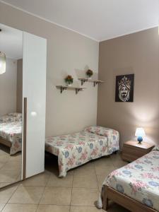a bedroom with two beds and a mirror at Nonna Croce Home in San Giovanni Gemini