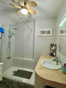 a bathroom with a shower and a sink and a ceiling fan at Ocean View Tenerife South Coast in Costa Del Silencio