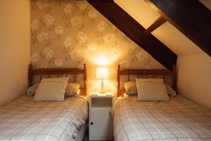 two beds in a attic room with a lamp at Oak Cottage at Scolton Cottages - Indoor pool in HAW +23 photos