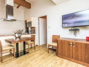 a kitchen and dining room with a table and a television on the wall at Apartment Emma-8 by Interhome in Dürnberg