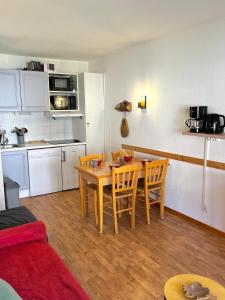 cocina y mesa y sillas en una habitación en Appartement 5 personnes - Lumière des Neiges A 209, en Valmeinier