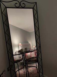 a mirror in a room with a table and a chair at La Casa della Rosa Nana in Trezzano sul Naviglio