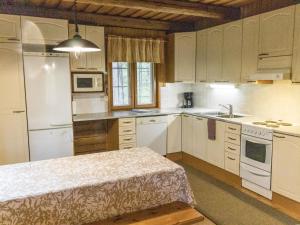 a kitchen with white cabinets and a table in it at Holiday Home Papula by Interhome in Puumala
