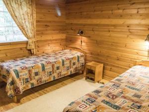 a bedroom with two beds in a log cabin at Holiday Home Papula by Interhome in Puumala +15 photos