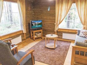 a living room with a couch and a tv at Holiday Home Papula by Interhome in Puumala