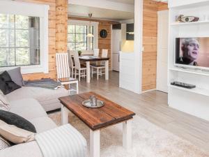 a living room with a couch and a table at Holiday Home Kiehtäjän lahti by Interhome in Käylä