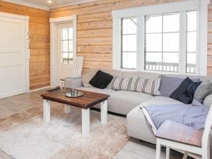 a living room with a couch and a table at Holiday Home Kiehtäjän lahti by Interhome in Käylä