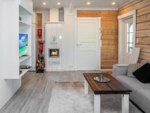 a living room with a couch and a fireplace at Holiday Home Kiehtäjän lahti by Interhome in Käylä +15 photos