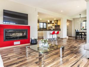 a living room with a red accent wall and a fireplace at Holiday Home Torre de Ven by Interhome in Vidreres