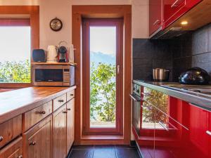 uma cozinha com um balcão com um micro-ondas e uma janela em Chalet Nelly by Interhome em Veysonnaz
