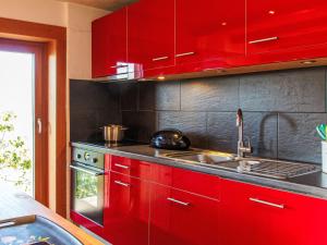 a kitchen with red cabinets and a sink at Chalet Nelly by Interhome in Veysonnaz +36 photos