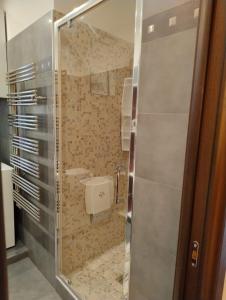 La salle de bains est pourvue d'un lavabo et d'une porte de douche en verre. dans l'établissement Conchiglia Magica Golfo dei Poeti, à La Spezia