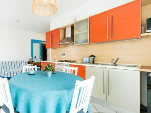 une cuisine avec une table et une cuisine avec des armoires orange dans l'établissement Apartment Casa dei Limoni by Interhome, à Arma di Taggia 22 autres photos