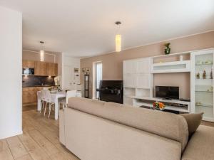 a living room with a couch and a kitchen at Apartment Il Melo-1 by Interhome in Garzeno