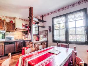 a kitchen with a table and some windows at Holiday Home Faisans by Interhome in Ondres