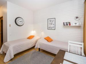 two beds in a room with a clock on the wall at Holiday Home Rautulampi g14 by Interhome in Saariselka