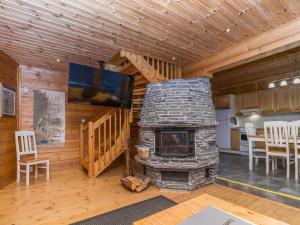 a living room with a stone fireplace and a tv at Holiday Home Alakoski by Interhome in Ivalo