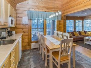 a kitchen and dining room with a wooden table and chairs at Holiday Home Alakoski by Interhome in Ivalo +19 photos