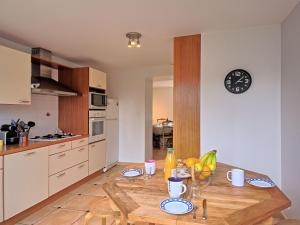 a kitchen with a wooden table and a clock on the wall at Holiday Home Charme de la pointe de Penchâteau by Interhome in Le Pouliguen