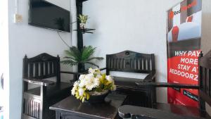 a dining room with a table with flowers on it at RedDoorz at Plus Villa Gloria Taguig in Manila