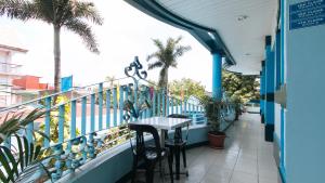 a balcony with a table and some palm trees at RedDoorz at Plus Villa Gloria Taguig in Manila