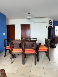 a dining room with a wooden table and chairs at Departamento Punta Centinela frente al mar in Santa Elena
