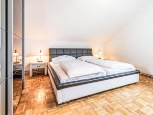 a bedroom with a large bed and a wooden floor at Apartment Ferienwohnung Grimmingblick by Interhome in Öblarn +21 photos