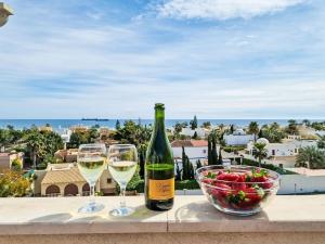 two glasses of wine and a bowl of fruit on a table at Apartment Sotavento by Interhome in Los Amarguillos