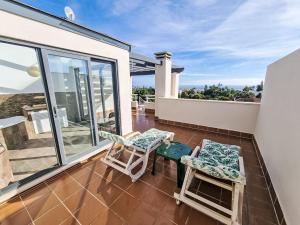 a balcony with two chairs and windows on a house at Apartment Sotavento by Interhome in Los Amarguillos