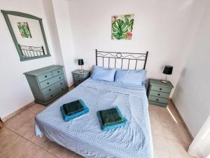 a bedroom with a bed with two dressers and two mirrors at Apartment Sotavento by Interhome in Los Amarguillos +18 photos