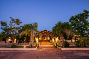 Un edificio con palmeras delante. en Hotel La Castellana, en Paysandú