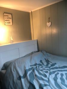 a bed with a blue comforter in a room at Appartement in schuur in Twisk