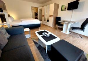 a living room with a couch and a bed at Appartementhaus Berlin in Bad Füssing