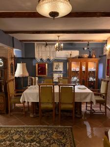 a dining room with tables and chairs and a chandelier at Bujtina Sidheri in Korçë
