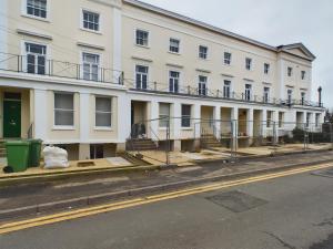 a large white building on the side of a street at Grosvenor New Fresh Central Wifi in Gloucestershire