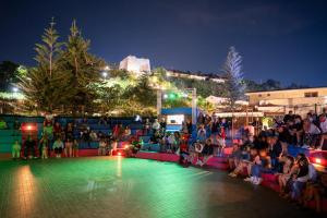 Hotel Villaggio Roller Club في كابو فاتيكانو: زحمة الناس جالسين حول المسبح بالليل