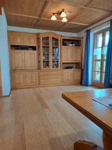 a large kitchen with wooden cabinets and a wooden table at Ferienwohnung Schwarzenberger in Lenggries +10 photos