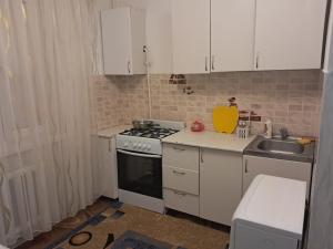 a small kitchen with a stove and a sink at 1 комн квартира рн Сазда БЦ МИР в Центре in Aktobe
