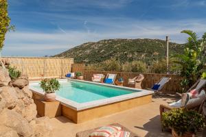 ポルト・サン・パーオロにあるSmart Appart Sweet Country House Sardiniaの背景に山があるスイミングプール(椅子付)