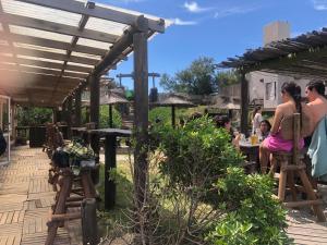 a group of people sitting at a table under a pergola at Hostel Playa Pura Vida mdq in Mar del Plata +11 photos