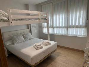 ein Schlafzimmer mit einem Etagenbett und Handtüchern darauf in der Unterkunft Apartamentos Turísticos SANTA APOLONIA 62 in Avilés