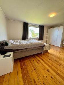a bedroom with a bed and a wooden floor at Emil Hemma in Järnforsen