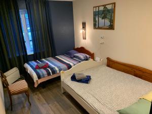 a bedroom with two beds and a chair in it at Delta 10- two big beds in Tartu