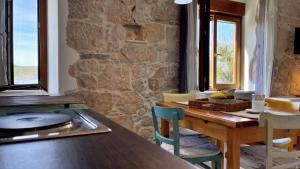 a kitchen with a wooden table and a stone wall at Apartments Gorisek in Šilo