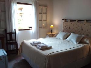 a bedroom with a large bed with towels on it at HOSTERÍA SAJONIA in Villa Gesell +18 photos