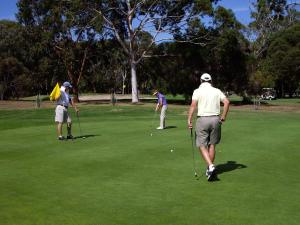 three people playing golf on a golf course at Yelki by the Sea in Encounter Bay