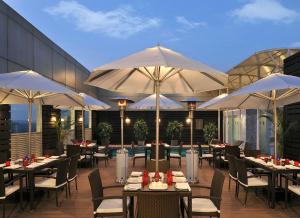 a restaurant with tables and chairs and umbrellas at Park Plaza Faridabad in Faridabad