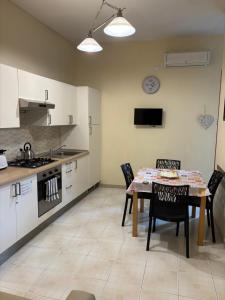 een keuken met een tafel en stoelen in een keuken bij La Piccola Reggia in Napels